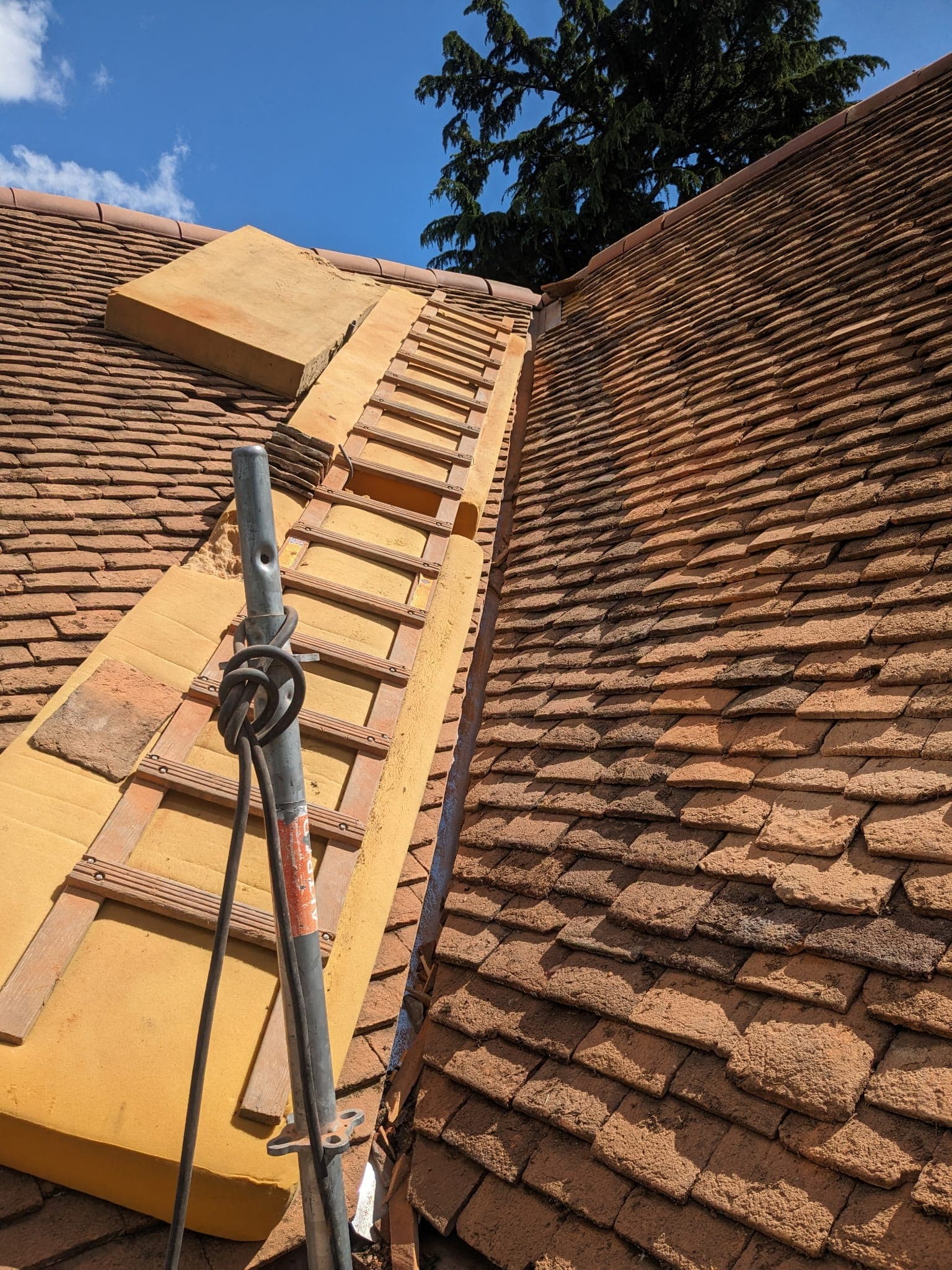 Réfection du faîtage d'une toiture en tuiles par le couvreur